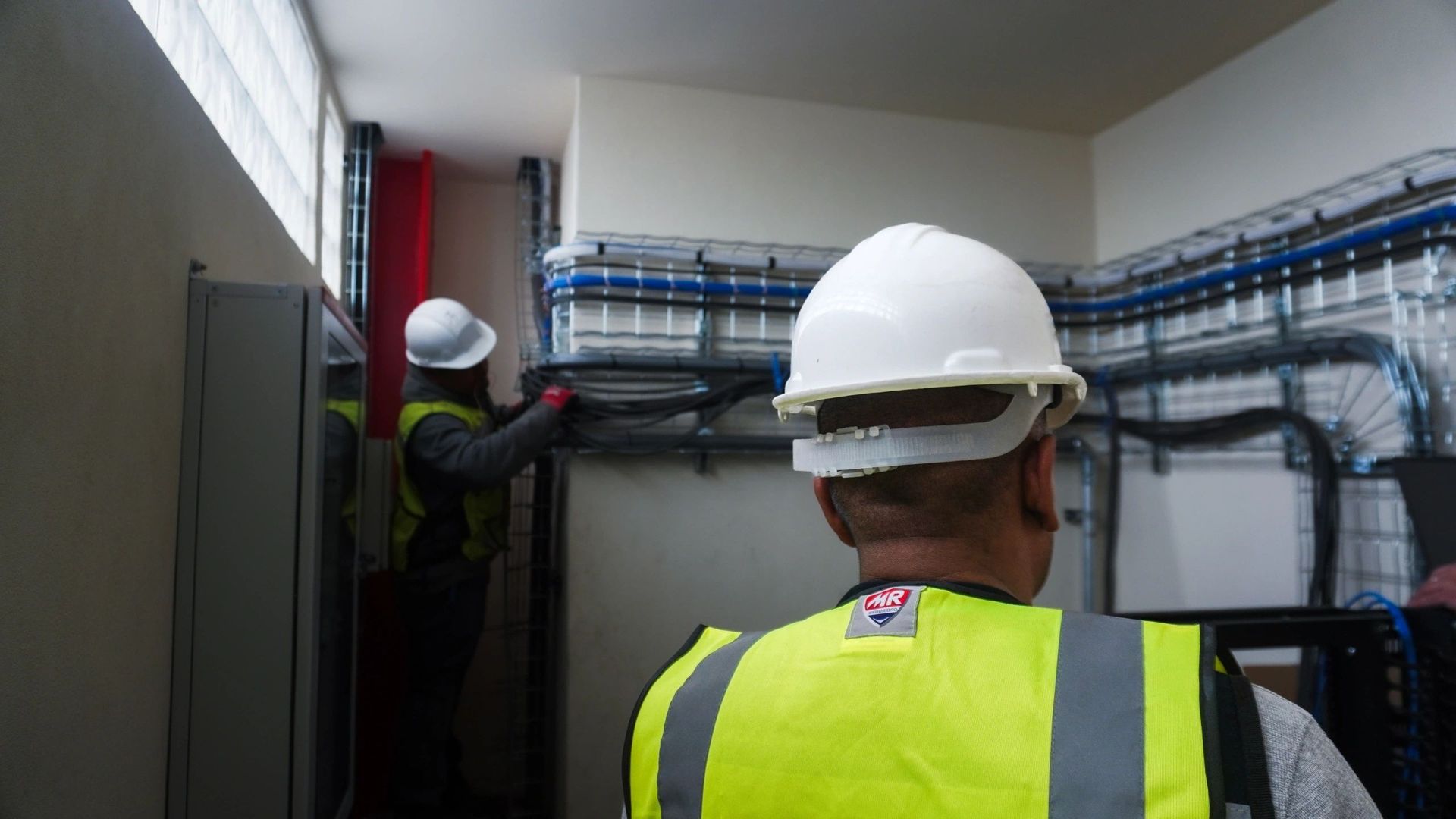 Trabajadores con casco instalando cables